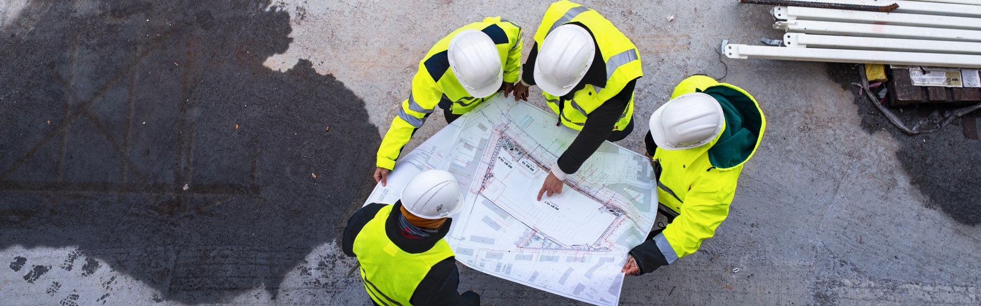 Overhead view of workers onsite reading technical details